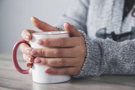 woman hand  cup of coffee on deskの写真素材