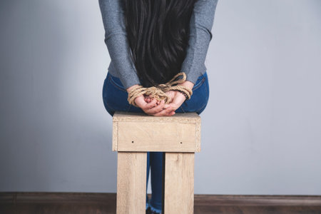 woman hands bound on the dark wall backgroundの写真素材