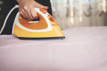 young woman ironing in the home backgroundの写真素材