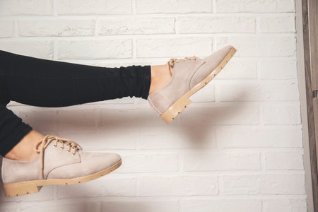 woman foot sport shoes on brick wall backgroundの写真素材