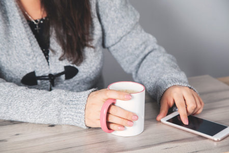 woman hand cup of coffee with  smart phone
