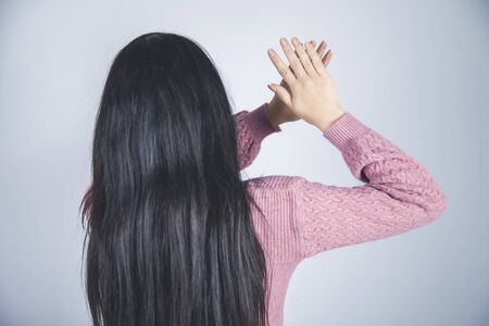 young woman hand stop sign on gray backgroundの写真素材