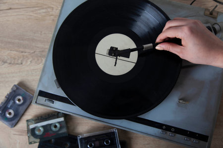 woman hand vintage gramophone on the wooden desk 