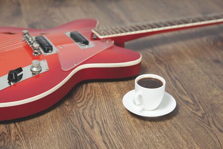 guitar with cup of coffee on the wooden backgroundの写真素材