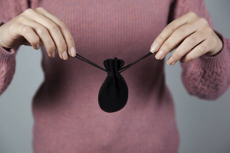 woman hand black gift bag on gray backgroundの写真素材