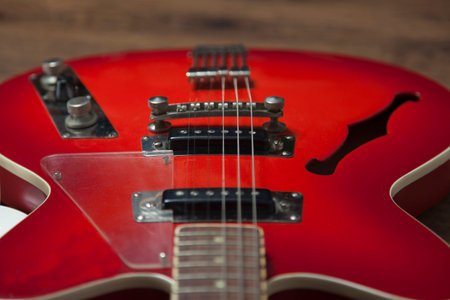 red wooden guitar on the wooden backgroundの写真素材