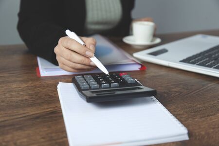 woman hand calculator with coins on deskの写真素材
