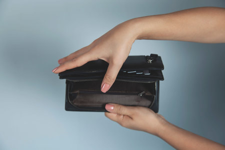 young woman hand holding black empty wallet