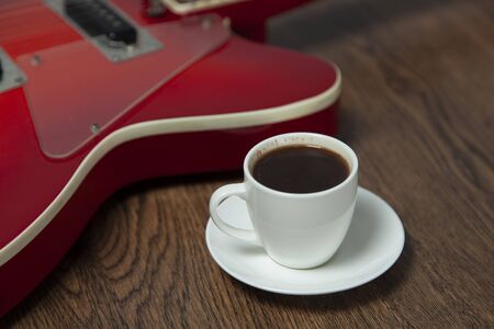 guitar with cup of coffee on the wooden backgroundの写真素材