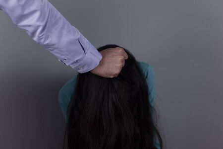 man beat woman  on gray wall backgroundの写真素材