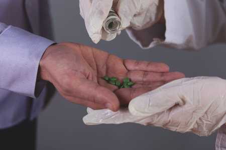doctor and ill hand drug on grey wall background