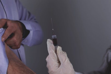 doctor hand syringe with ill on grey background