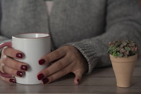  woman hand cup of coffee on the deskの写真素材