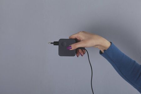A woman hand pulls a black cord in homeの写真素材