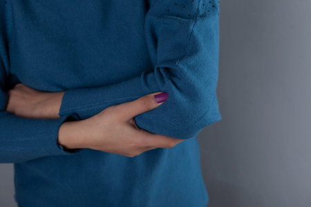 woman ache shoulder on the grey wall background