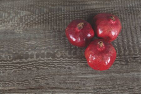 pomegranates on the wooden table backgroundの写真素材