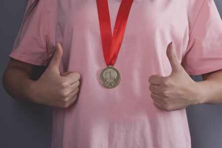 woman hand okay sign with medal on grey backgroundの写真素材
