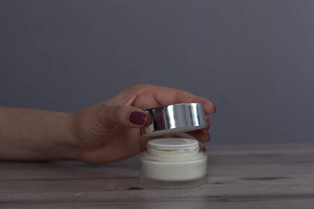 woman hand cream on gray wall backgroundの写真素材