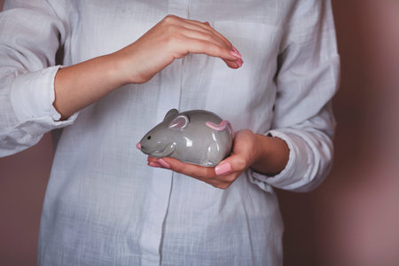 woman hand holding mouse toy on gray background