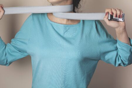 young sad woman hand belt in neckの写真素材