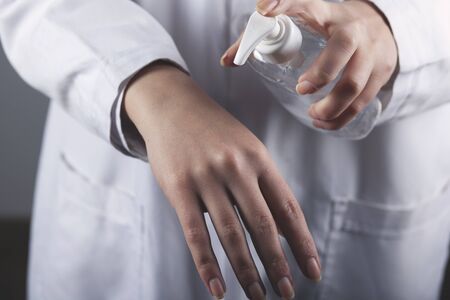 woman hand antimicrobial liquid gel on grey backgroundの写真素材