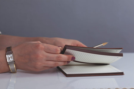 woman hand pen with notepad on the working desk
