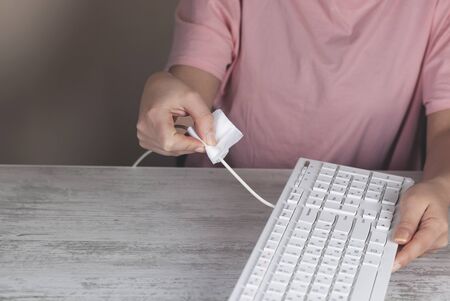 Woman cleaning pc keyboard on tableの写真素材