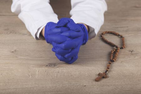 young women praying with rosary on wooden deskの写真素材