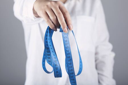 woman hand meter in belly on grey backgroundの写真素材