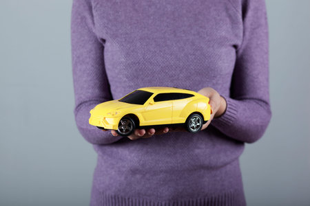 woman hand  car model on grey background
