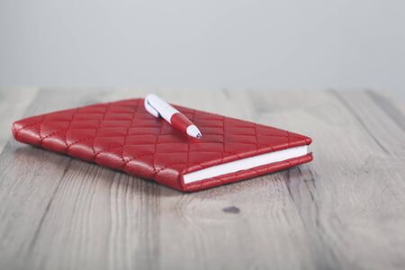 pen on red notepad on the tableの写真素材