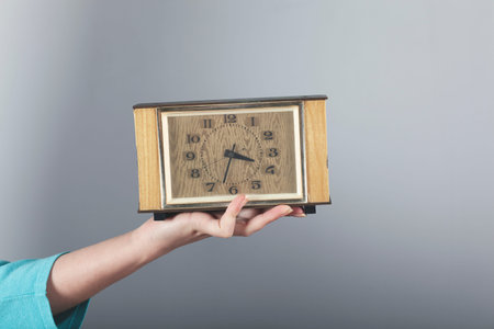 woman hand clock on the on gray background