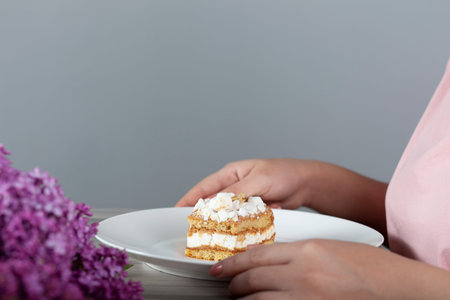 woman eat cake and drink coffee and lilac on table