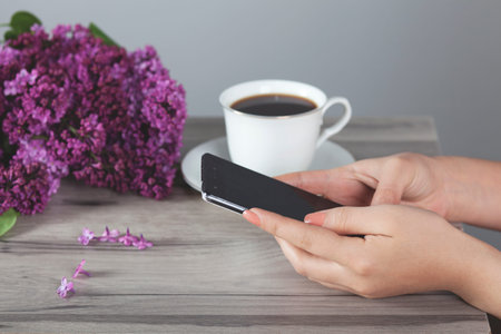  woman hand phone with coffee on the desk