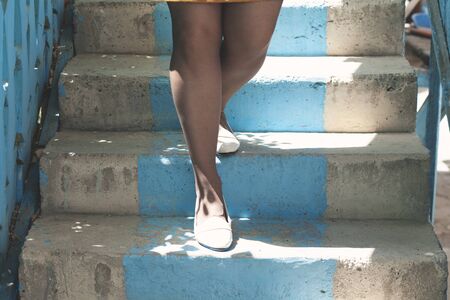 the young woman on the blue stairsの写真素材