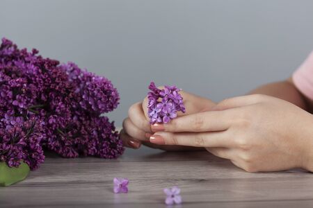 woman hand  lilac flowers on the tableの写真素材