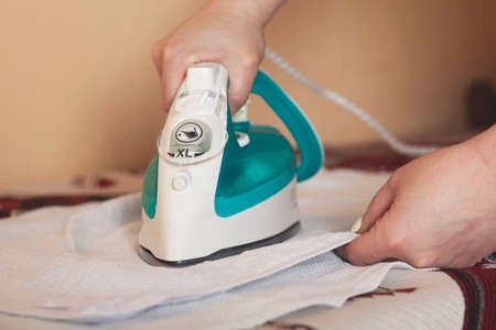 woman ironing clothes on table in the homeの写真素材