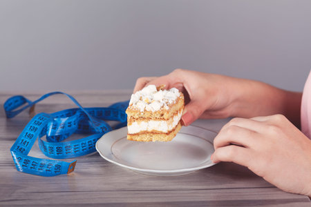 diet woman hand cake and meters on table
