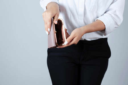Woman holds an empty wallet in hands outdoor. Finance problem conceptの写真素材