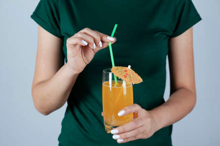 young woman holding glass of orange juice.の写真素材