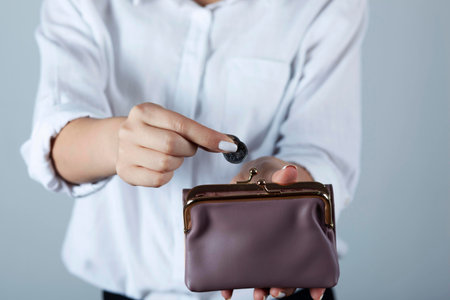 young woman hand holding coin with wallet