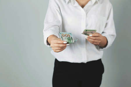 young woman hand money on gray backgroundの写真素材