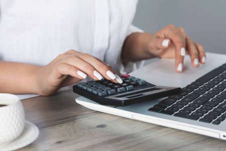 woman hand calculator with computer on the deskの写真素材