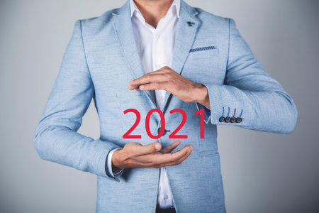 business man holding 2021 in the screen