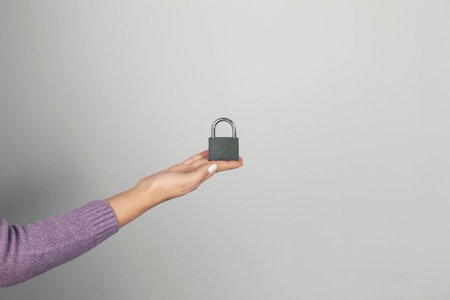 woman holding lock on gray backgroundの写真素材