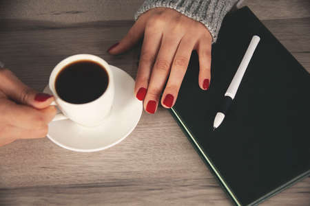woman hand cup of coffee on the deskの写真素材