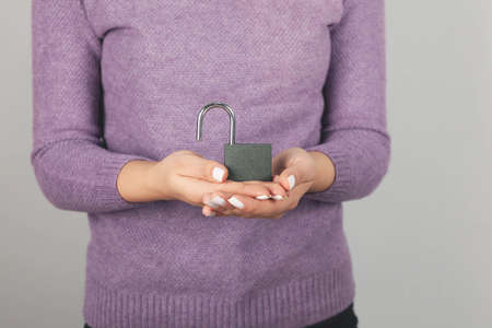 woman holding lock on gray backgroundの写真素材