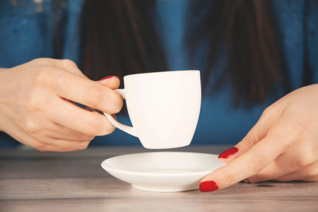 woman hand cup of coffee on the desk