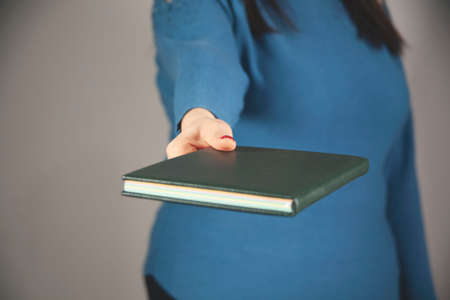 woman hand notepad on gray backgroundの写真素材