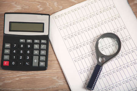 notepad with magnifier and calculator on deskの写真素材